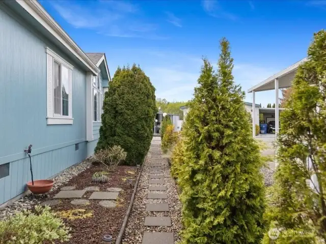 Paved side walkway with room for a garden and flowers.