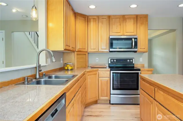 Ample kitchen with stainless appliances, granite tile counter tops and lots of storage.
