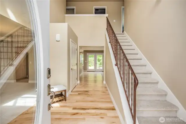 An entry that impresses with its sanded/re-stained wood floors and iron stair railing.