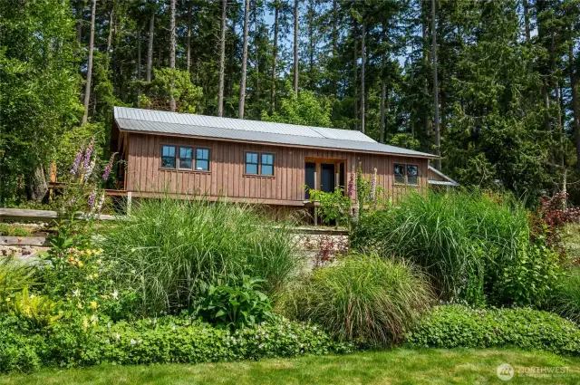The main building (carport/RV shelter and shop, with the main studio inside) and garden in the foreground
