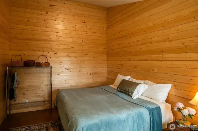 Main studio inside main building, with polished concrete floors, pine paneling, and en suite 3/4 bathroom
