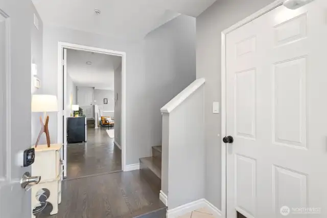 Front door entry with option to enter the studio, entrance to the attached garage, or upstairs to the main level. Note the  fingerprint keypad smartlocks on both doors.