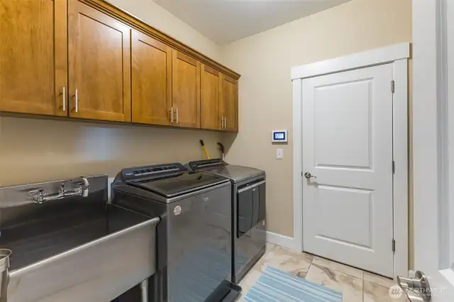 Laundry room with storage and utility sink.