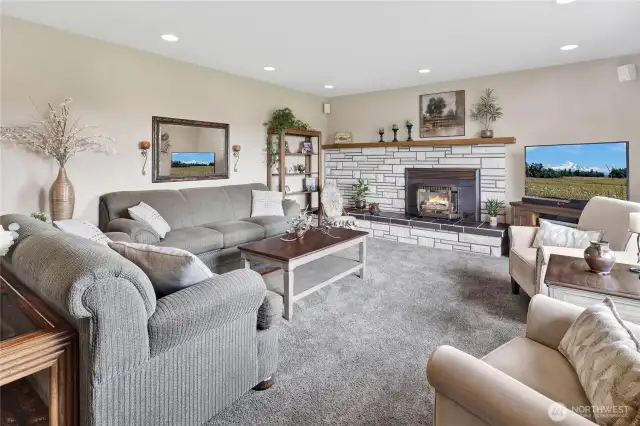 A comfortable and inviting living room welcomes you with plenty of natural light and a cozy gas fireplace, perfect for relaxing or gathering with loved ones.