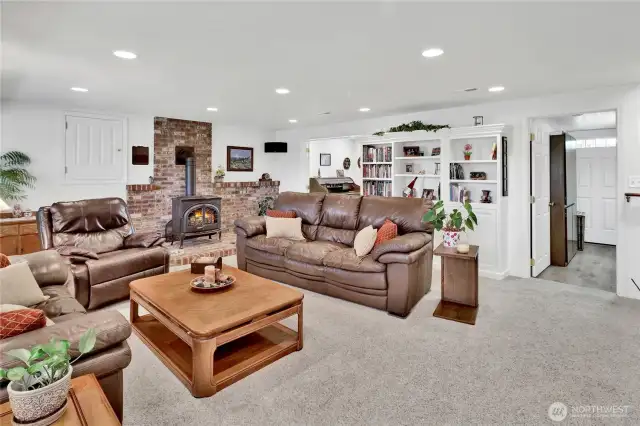 The free-standing stove adds warmth and coziness to the room, making it a perfect spot to relax. Two built-in safes offer extra security—one hidden behind the door to the left of the fireplace and the other cleverly concealed behind the picture to the right.