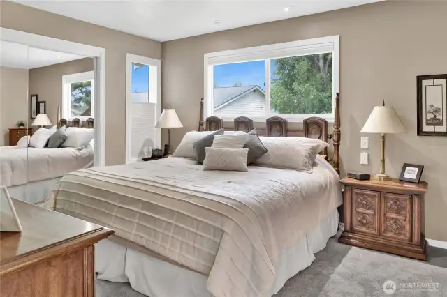The primary bedroom with its en-suite bath offers a surprising amount of storage, featuring two spacious 8-foot closets.