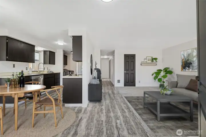 Virtual Staging-From Front Door.  LVP flooring throughout kitchen, dining, hallway, and primary bedroom. New carpet in living room and guest bedrooms.