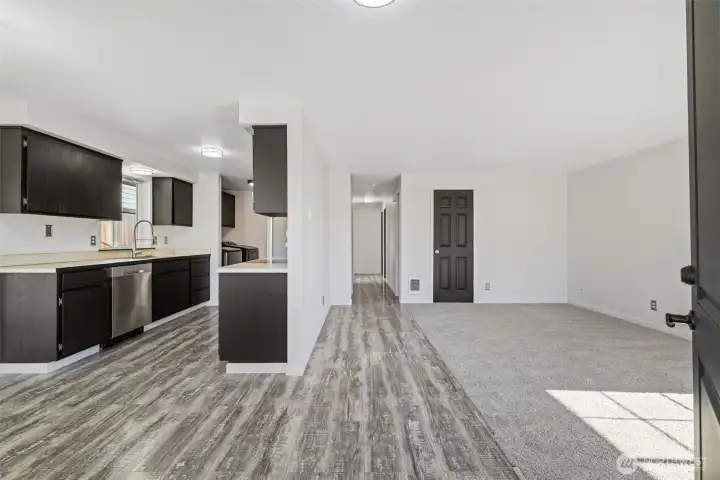 From Front Door.  LVP flooring throughout kitchen, dining, hallway, and primary bedroom. New carpet in living room and guest bedrooms.