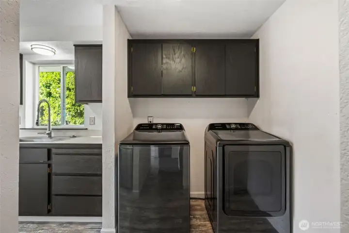 Laundry room offers ample space for movement and storage.