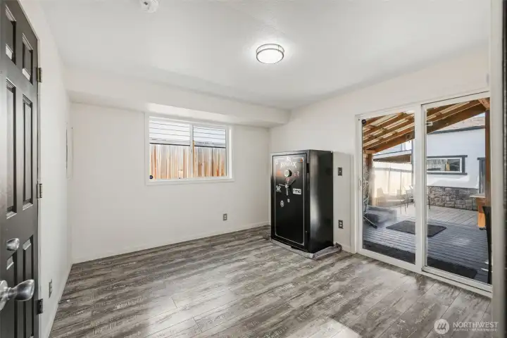 Primary bedroom with sliding glass doors leading to covered deck in backyard. Safe will be removed prior to closing.