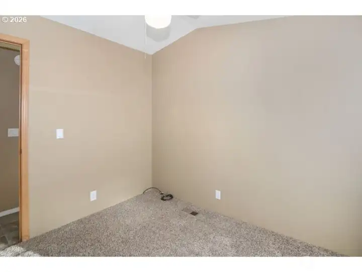 2nd bedroom with ceiling fan and vaulted ceilings.