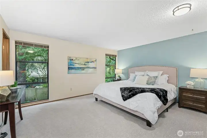 Spacious primary bedroom retreat with peaceful views of surrounding greenery.