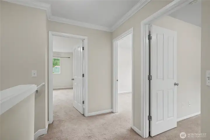 Upstairs landing shot showing your primary suite to the right with double doors and 2 additional bedrooms.