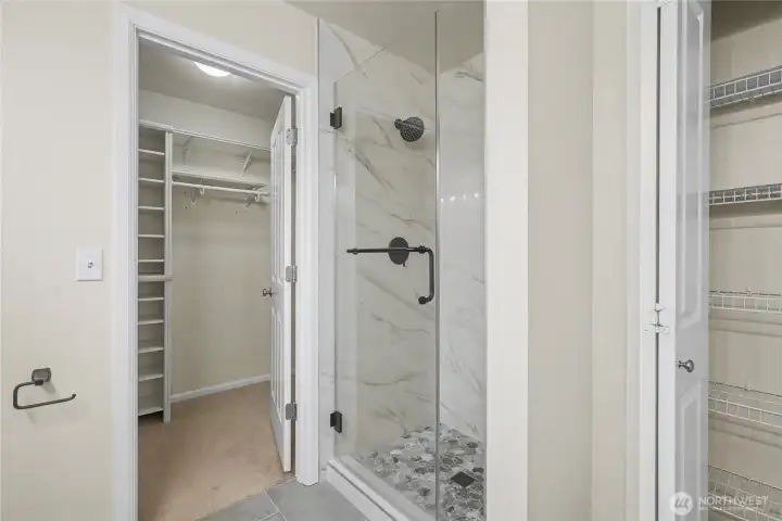 Primary ensuite bath view two showing walk-in closet, separate shower and linen closet.