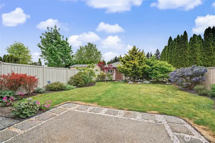 View of your AMAZING and large fully fenced-in backyard with beautiful landscaping, expanded patio, nice shed in the rear and territorial views.