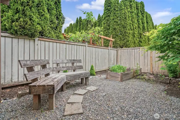 In the rear of your yard next to the shed, you will find this cute little hideaway space with benches, glass of wine anyone?