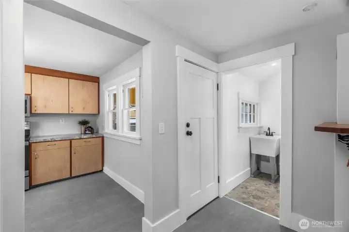 This hallway is just beyond the dining area, with the kitchen on the left, the middle door is an exit to the back patio, and the utility room is on the right. This hallway is just beyond the dining area, with the kitchen on the left, the middle door is an exit to the back patio, and the utility room is on the right.