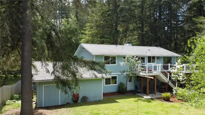 The garage has storage/workshop space at the back with doors to the back yard.  The deck has great views and the patio below provides shade and more outdoor space to enjoy.  The door near the patio opens to the lower level of the home.