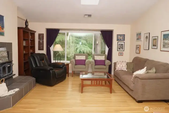 The main living room has lovely hardwood floors, vaulted ceiling and skylight.