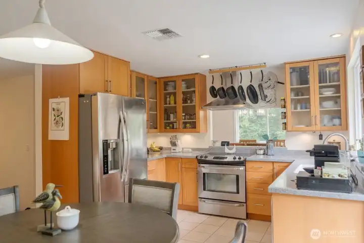 The kitchen has tile flooring and updated cabinetry. A passthrough over the range opens to the dining room.