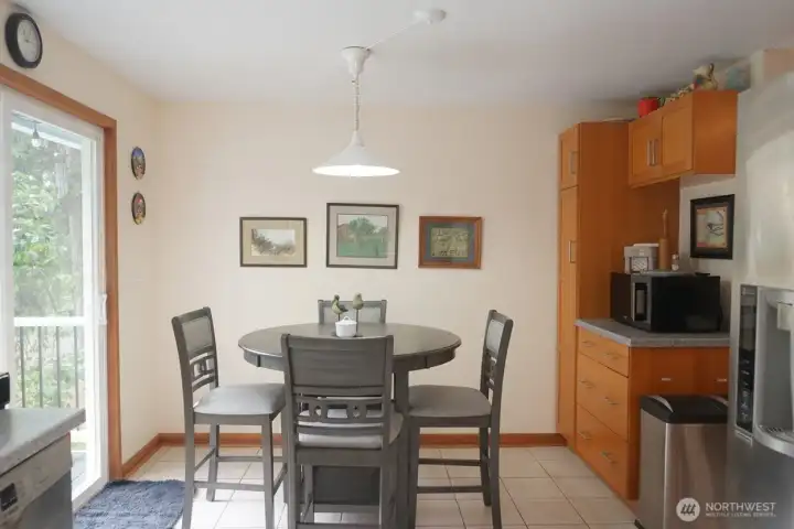 Eating area in the kitchen with sliding door to the deck and a lovely view of the lake and trees.