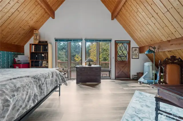 Primary bedroom with large windows and door to deck