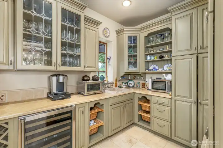 Butlers pantry off the kitchen with granite sink, notice ample storage with closed cabinets.