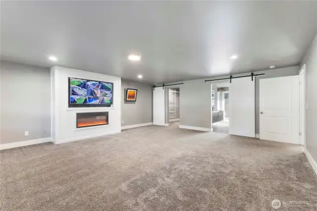 Main level primary suite with electric fireplace and the tv conveys.