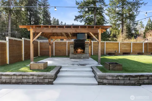 Gazebo with fireplace beside pool.