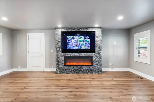Electric fireplace in living space and the tv conveys. Note the security system display.