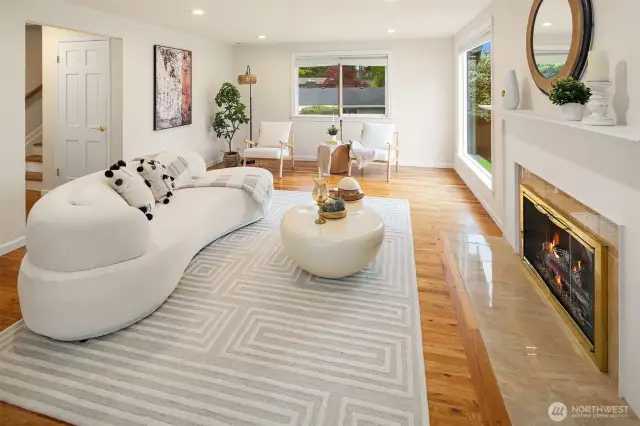 spacious living room offers a second gas fireplace, hardwood floors and walls of windows that fill the space with natural light.