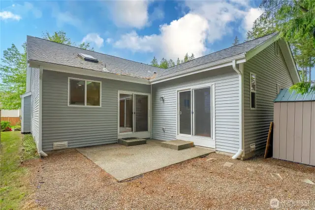 Showing the back of the home w/ a patio, two sliding doors, and plenty of room for BBQing.