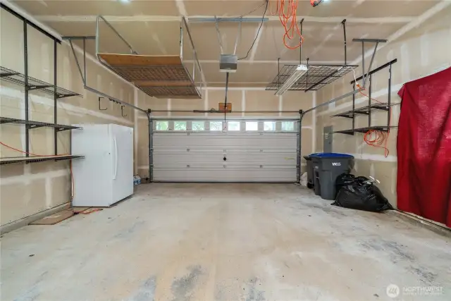 Oversized 2-car garage has custom overhead storage.