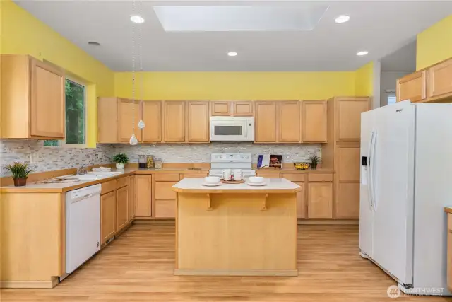 Cheerful kitchen is huge! Look at all those cabinets and counterspace.