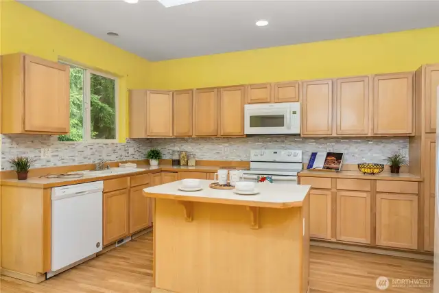 Custom backsplash will work with any color of paint. Center island has room for a couple of bar stools.