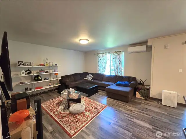 Spacious living room with built-ins. Notice the mini-split! Keeping you cool or warm all year long. Nice LVP flooring