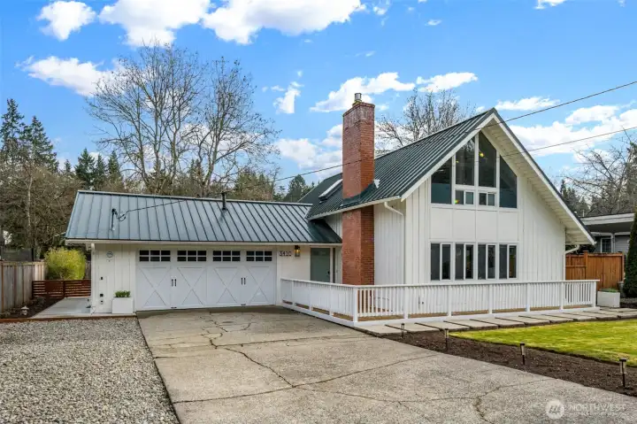 Lovely curb appeal with refreshed, easy-maintenance landscaping and a large, flat front yard. The wide, level driveway offers parking for six or more cars, and the gravel driveway provides additional space for a boat or RV. The home features a newer long-lasting metal roof, modern exterior colors, a double garage, and a stone walkway that goes all the way around the house, connecting the outdoor spaces seamlessly.