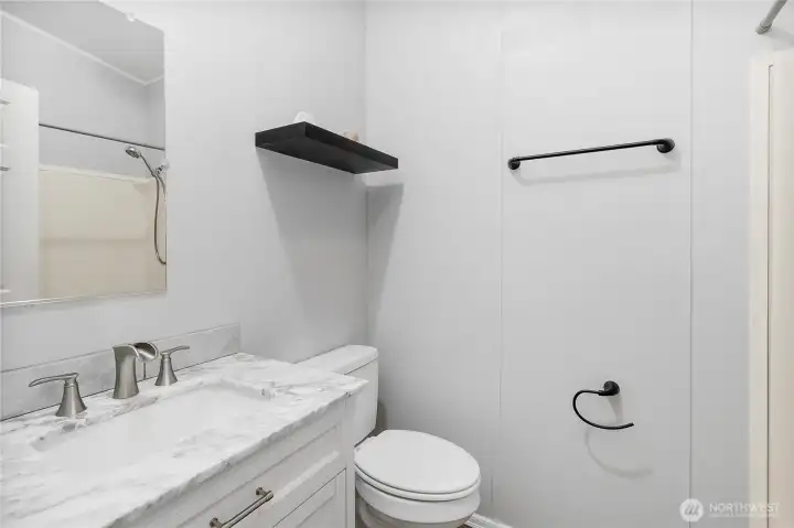 Guest bathroom with a tub shower surround.