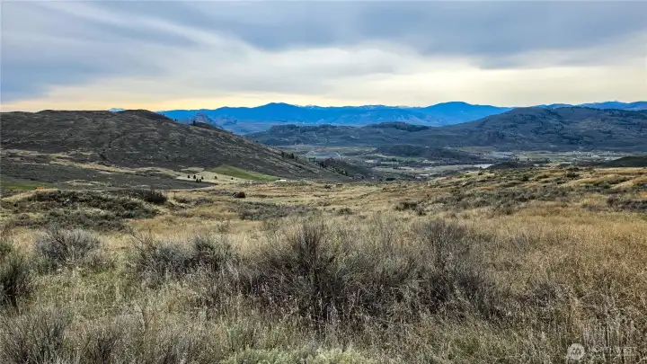 Spectacular SW Views from Center-West. Looking Southwest from the heart of the property. Ideal orientation for sunsets and natural light. Power in road. Easy access to Tonasket & Oroville!