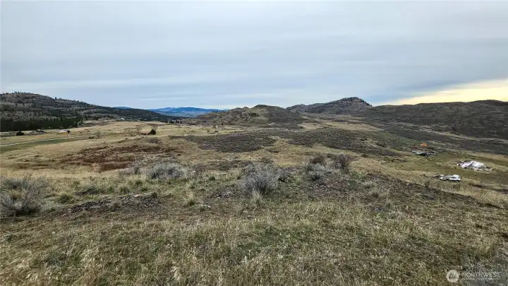 Panoramic 360-Degree Views. Standing on a great level area looking out at the horizon. Build-ready lot with power at street. Minutes to Tonasket/Oroville amenities.