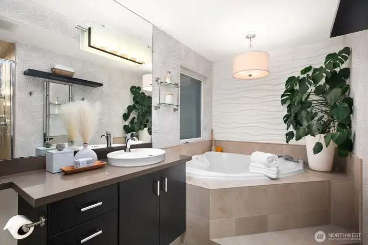 ...the luxurious primary suite bath with jetted soaking tub and separate shower...