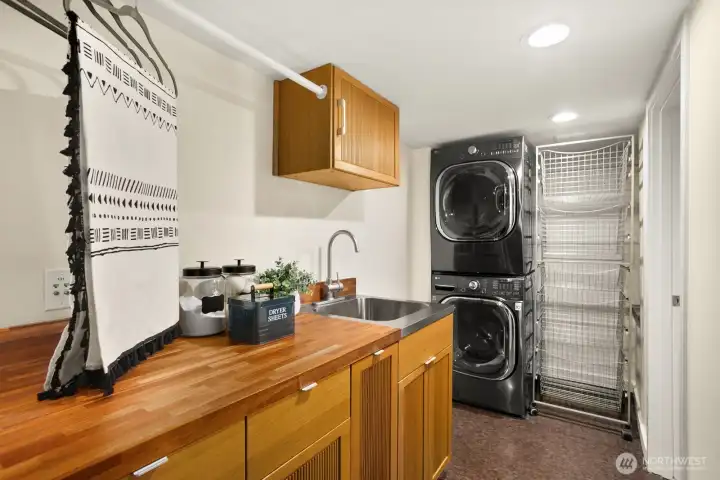 Laundry center with generous storage and wheeled rack allowing access to second electrical panel.