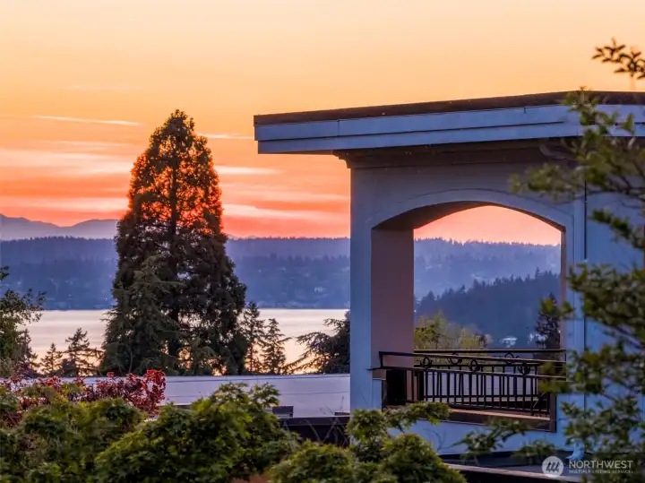 View from Primary bedroom balcony: Captivating sunset view from the Primary Suite's private balcony, framed by graceful archway detailing.