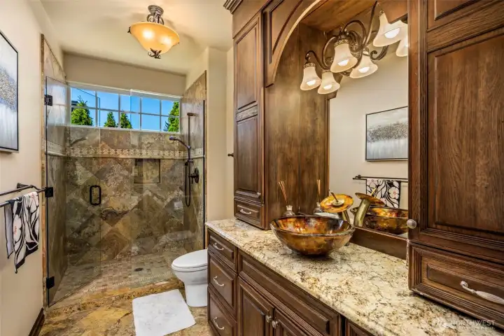 Main Floor Bathroom: Elegant main-floor bath with custom wood cabinetry, granite counters, and refined architectural detailing.