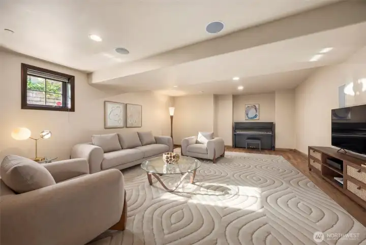 Lower level rec room: Spacious lower-level recreation room with cozy fireplace, built-in media area, and comfortable lounging space — ideal for movie nights or casual gatherings. With fridge and cabinets.