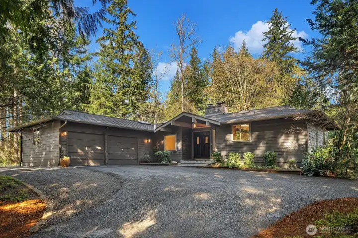 This stunning Sammamish home makes a lasting first impression with its charming curb appeal, featuring a circular pull-through driveway, lush mature landscaping, and a welcoming covered entry. The classic Northwest architectural style is complemented by a newer roof and beautifully maintained grounds offering exceptional privacy.