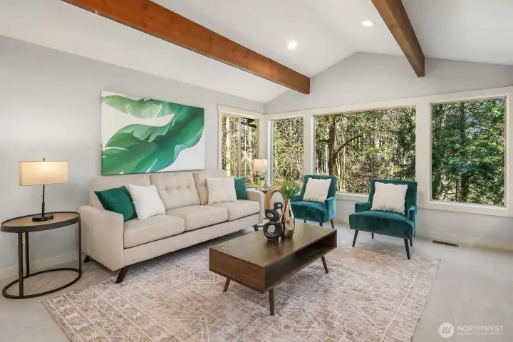 The inviting living room impresses with soaring vaulted ceilings accented by beautiful exposed beams, brand new designer carpet, and walls of windows that flood the space with natural light and bring the lush outdoors in. This bright, airy retreat provides the perfect setting for both relaxed everyday living and elegant entertaining.