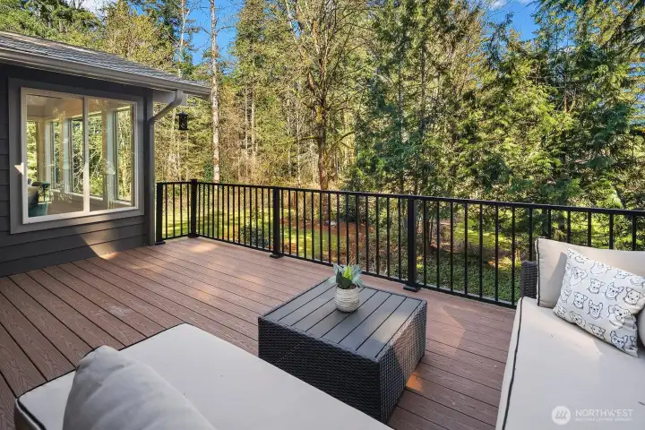 Step outside to this expansive deck offering a serene, private outdoor living space surrounded by a canopy of mature Pacific Northwest evergreens — the perfect setting for morning coffee, evening entertaining, or simply unwinding in nature. Accessible directly from the living room, this deck seamlessly extends the home's indoor-outdoor lifestyle.