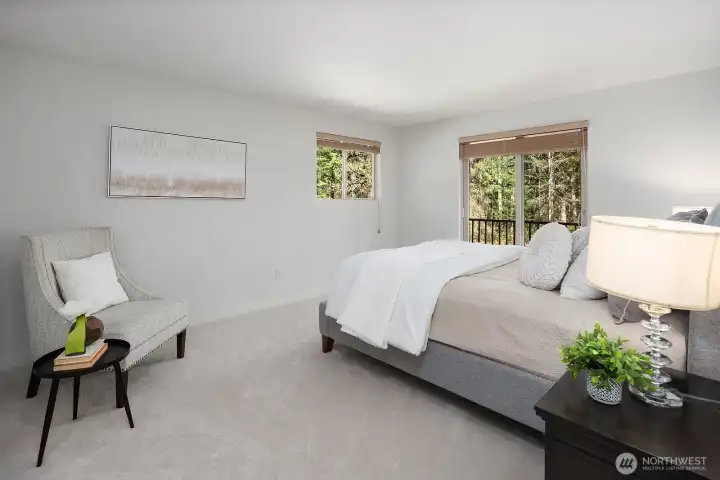 The spacious primary suite offers a serene and restful retreat, featuring plush new designer carpet, fresh interior paint, and large windows that bathe the room in soft natural light while framing views of the lush surroundings. Generously sized and thoughtfully appointed, this peaceful haven provides the perfect escape at the end of the day.
