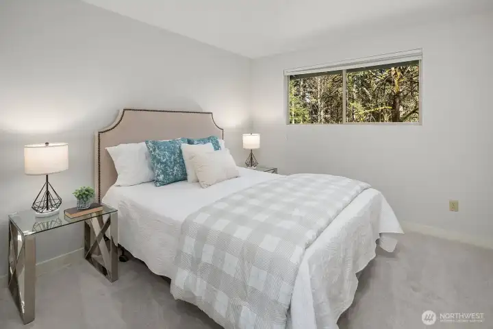 This bright and comfortable secondary bedroom features plush new designer carpet, fresh interior paint, and a large window that fills the space with warm natural light. Generously sized and move-in ready, this versatile room is perfect as a guest room, home office, or children's bedroom.